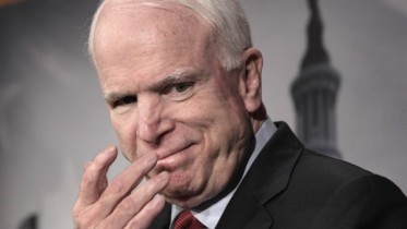 In this photo taken Dec. 14, 2011, Sen. John McCain, R-Ariz., smiles during a news conference on Capitol Hill in Washington. McCain has drawn the ire of Russian Prime Minister Vladimir Putin after the senator goaded Putin in a Twitter post about mass protests in Russia over alleged vote fraud. Putin lashed back at  McCain saying, "He has a lot of blood of peaceful civilians on his hands," referring to McCain's role as a combat pilot and prisoner of war in Vietnam. (AP Photo/J. Scott Applewhite)